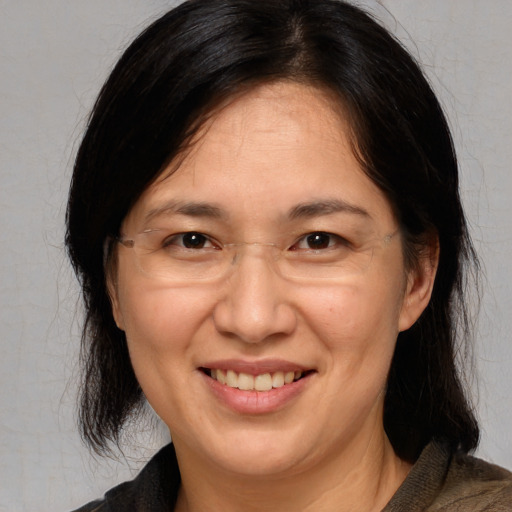 Joyful white adult female with medium  brown hair and brown eyes