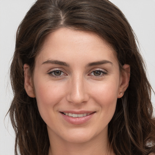 Joyful white young-adult female with long  brown hair and grey eyes