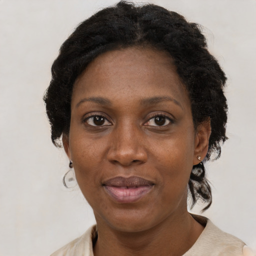 Joyful black adult female with medium  black hair and brown eyes