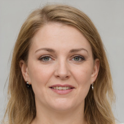 Joyful white adult female with long  brown hair and grey eyes