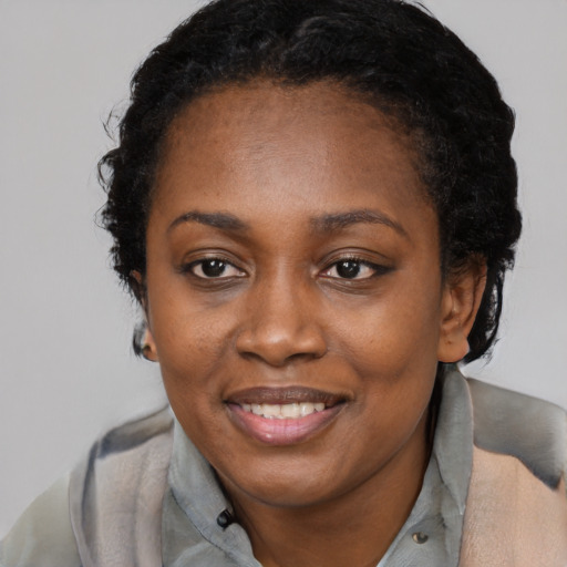 Joyful black young-adult female with short  black hair and brown eyes