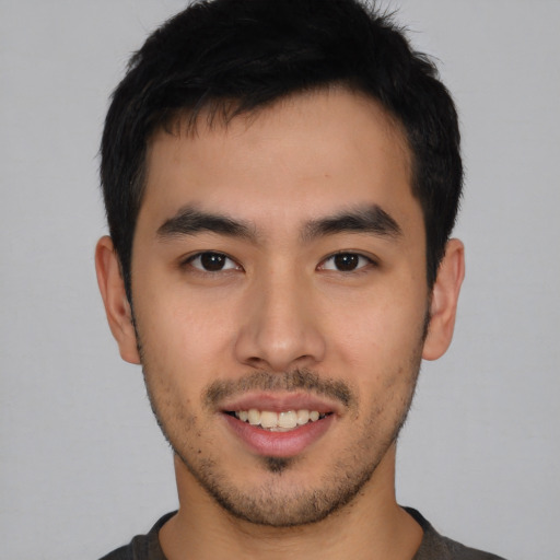 Joyful asian young-adult male with short  black hair and brown eyes