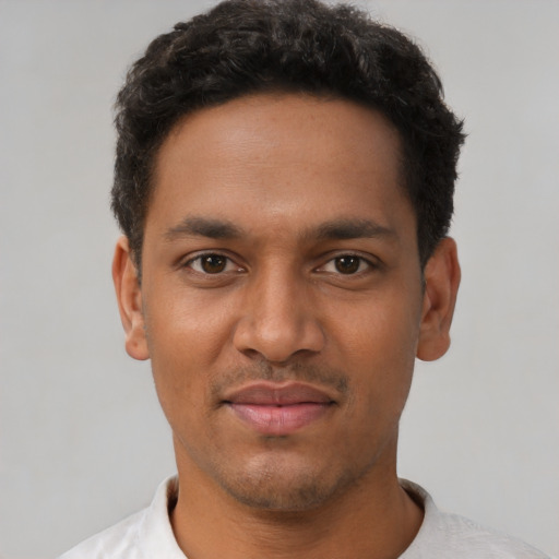 Joyful black young-adult male with short  black hair and brown eyes
