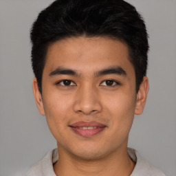 Joyful latino young-adult male with short  brown hair and brown eyes