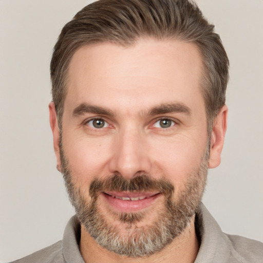 Joyful white adult male with short  brown hair and brown eyes