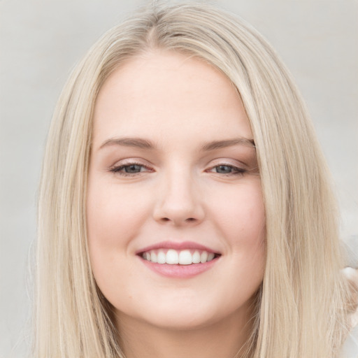 Joyful white young-adult female with long  brown hair and blue eyes