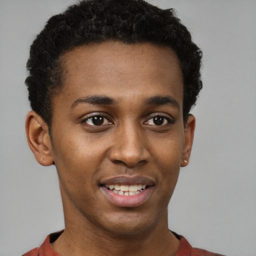 Joyful black young-adult male with short  black hair and brown eyes