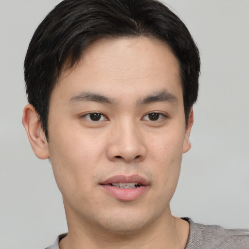 Joyful asian young-adult male with short  black hair and brown eyes