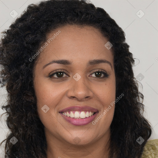 Joyful black young-adult female with long  brown hair and brown eyes