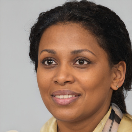 Joyful black adult female with long  black hair and brown eyes