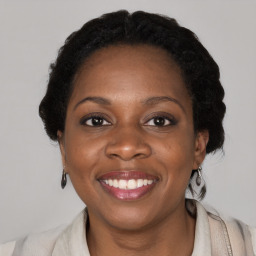 Joyful black adult female with medium  brown hair and brown eyes