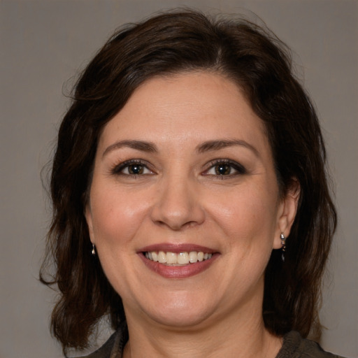 Joyful white adult female with medium  brown hair and brown eyes