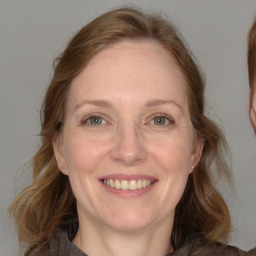 Joyful white adult female with medium  brown hair and blue eyes