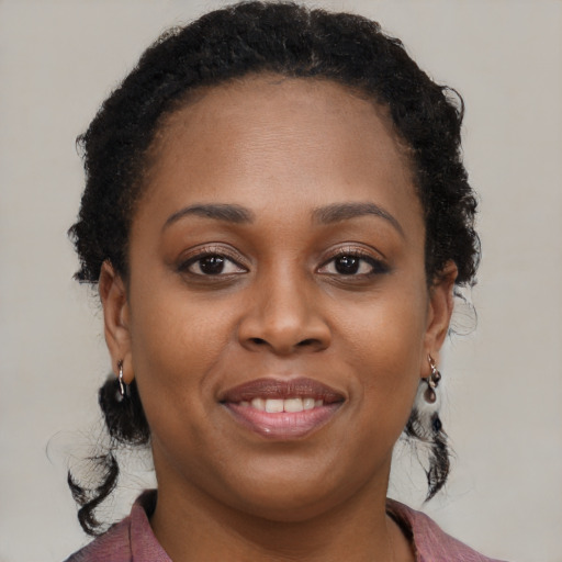 Joyful black young-adult female with long  brown hair and brown eyes