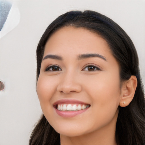 Joyful latino young-adult female with long  black hair and brown eyes