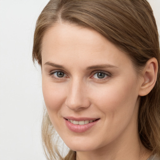 Joyful white young-adult female with long  brown hair and grey eyes