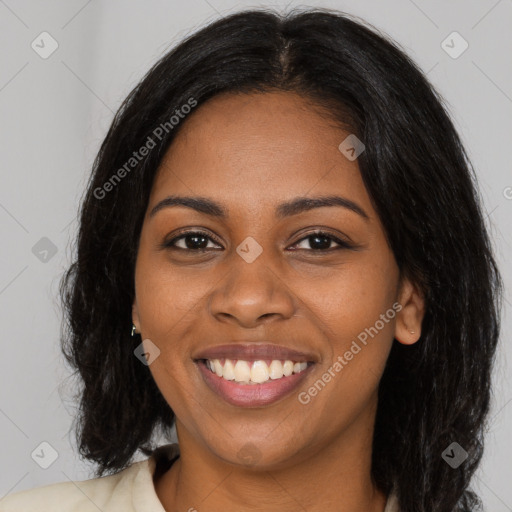 Joyful black young-adult female with long  black hair and brown eyes