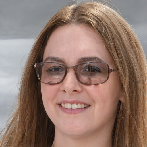 Joyful white adult female with long  brown hair and blue eyes