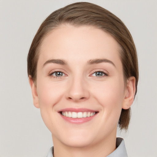 Joyful white young-adult female with medium  brown hair and grey eyes