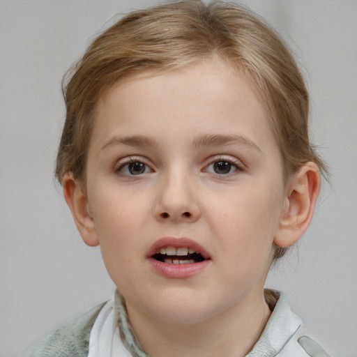 Joyful white child female with short  brown hair and blue eyes