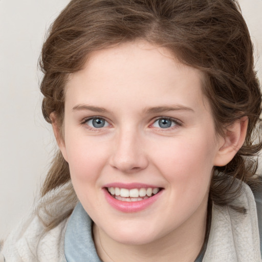 Joyful white young-adult female with medium  brown hair and blue eyes