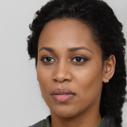 Joyful black young-adult female with long  black hair and brown eyes