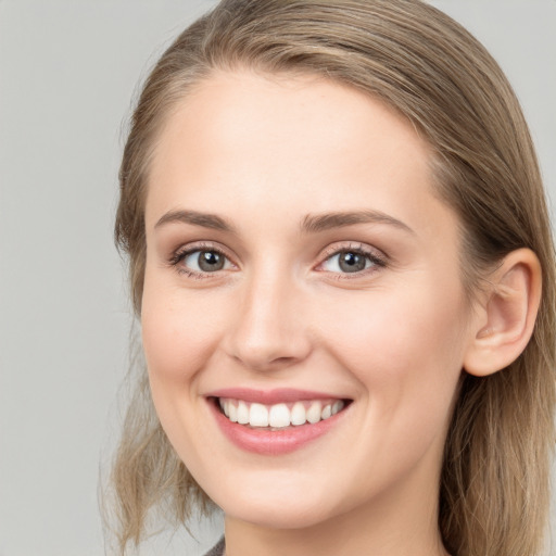 Joyful white young-adult female with long  brown hair and blue eyes