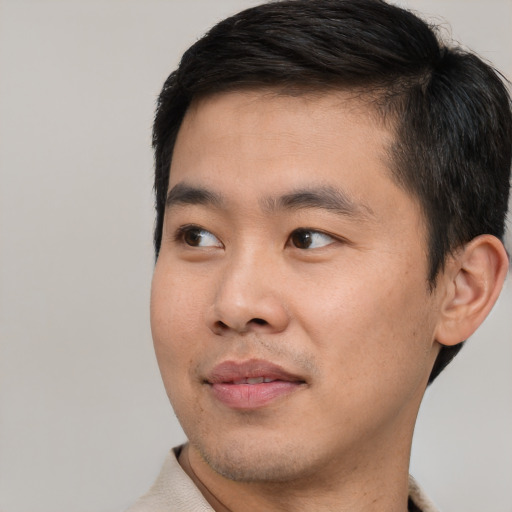 Joyful asian young-adult male with short  black hair and brown eyes
