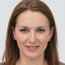 Joyful white young-adult female with long  brown hair and grey eyes