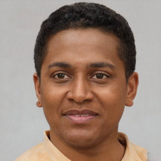 Joyful latino young-adult male with short  brown hair and brown eyes