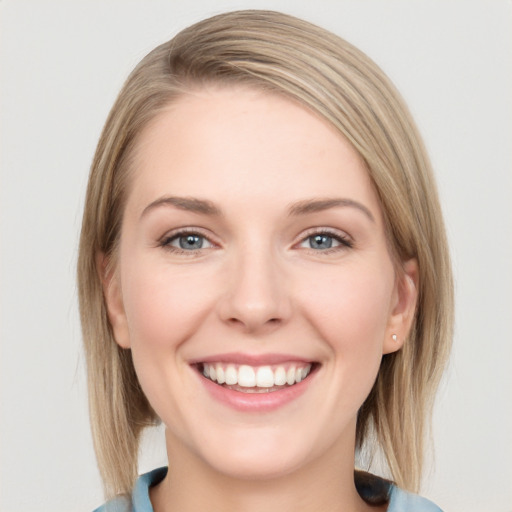 Joyful white young-adult female with medium  brown hair and blue eyes