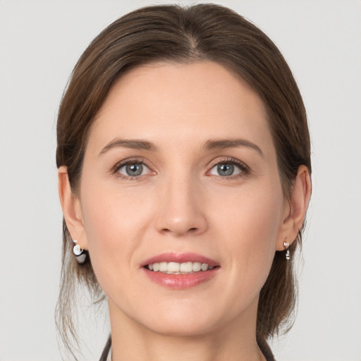 Joyful white young-adult female with medium  brown hair and grey eyes