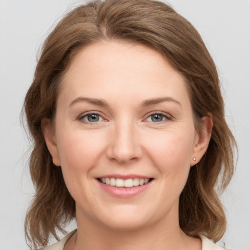 Joyful white young-adult female with medium  brown hair and grey eyes