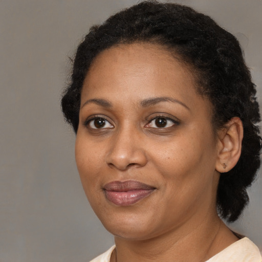 Joyful black adult female with medium  brown hair and brown eyes