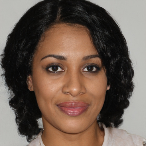 Joyful black young-adult female with medium  black hair and brown eyes