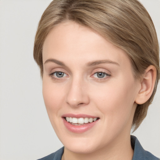 Joyful white young-adult female with medium  brown hair and grey eyes