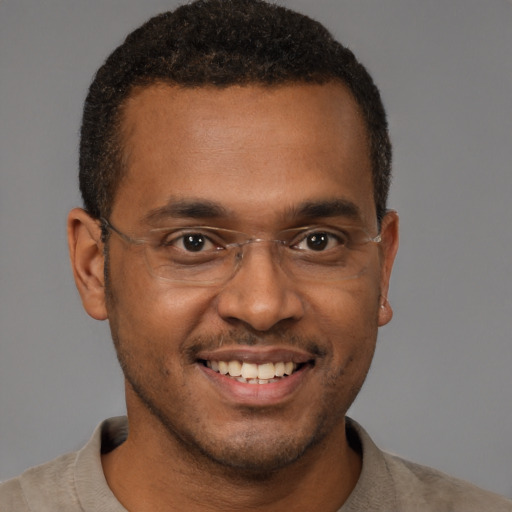 Joyful black young-adult male with short  brown hair and brown eyes