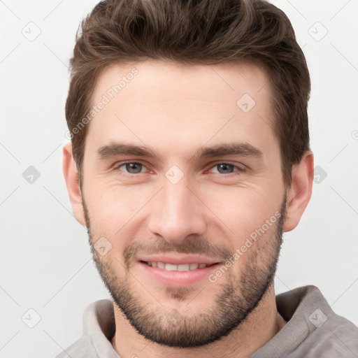 Joyful white young-adult male with short  brown hair and grey eyes