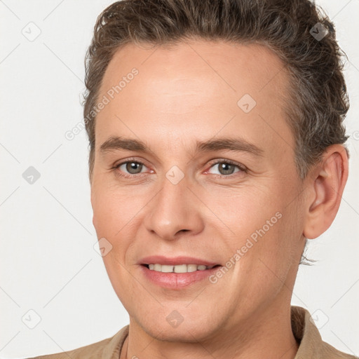 Joyful white adult male with short  brown hair and brown eyes