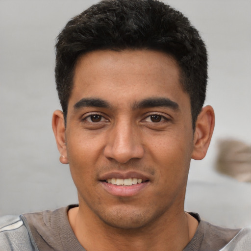 Joyful latino young-adult male with short  black hair and brown eyes