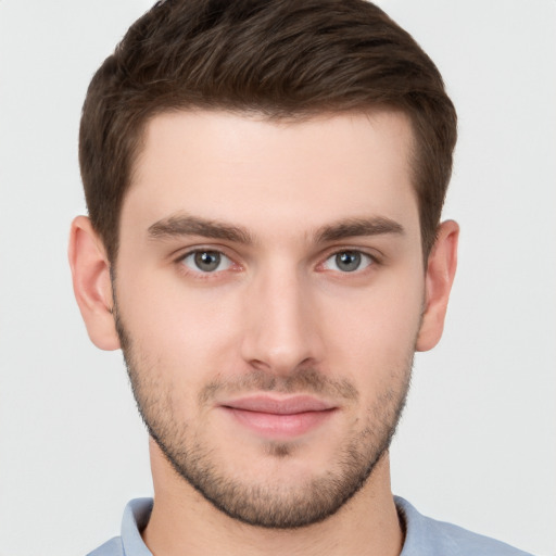 Joyful white young-adult male with short  brown hair and grey eyes