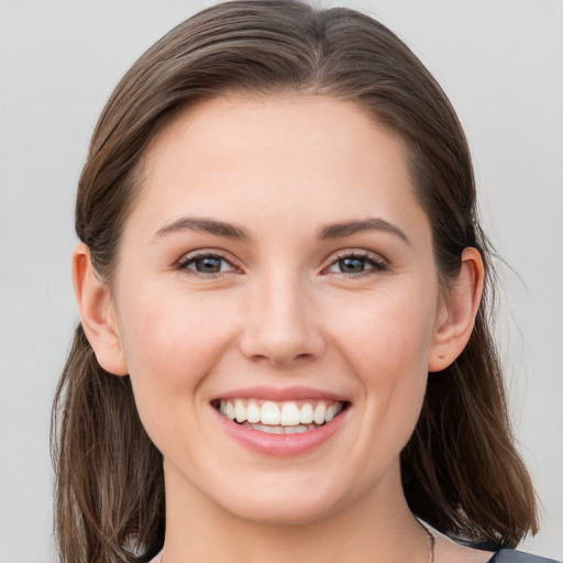 Joyful white young-adult female with long  brown hair and grey eyes