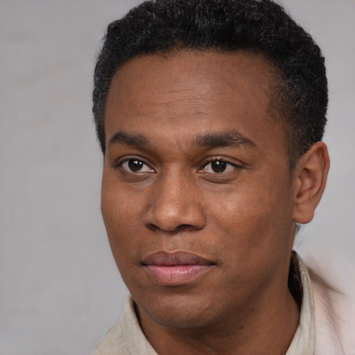Joyful black young-adult male with short  black hair and brown eyes