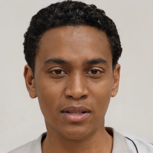 Joyful black young-adult male with short  black hair and brown eyes