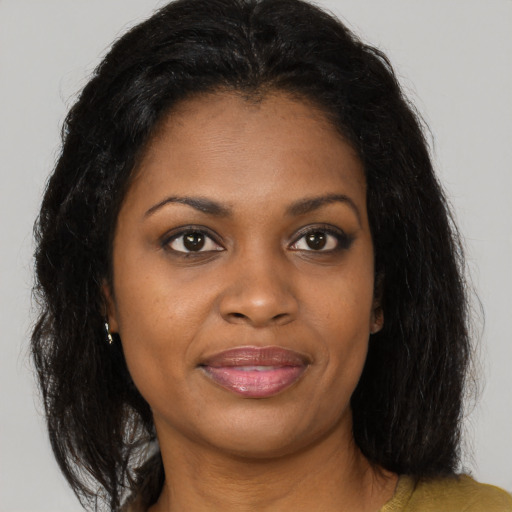 Joyful black young-adult female with long  brown hair and brown eyes