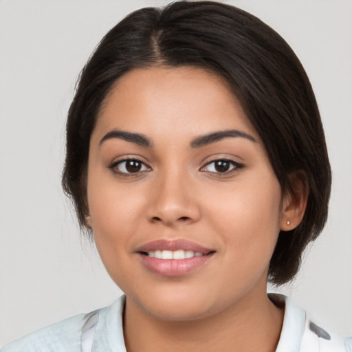 Joyful latino young-adult female with medium  brown hair and brown eyes