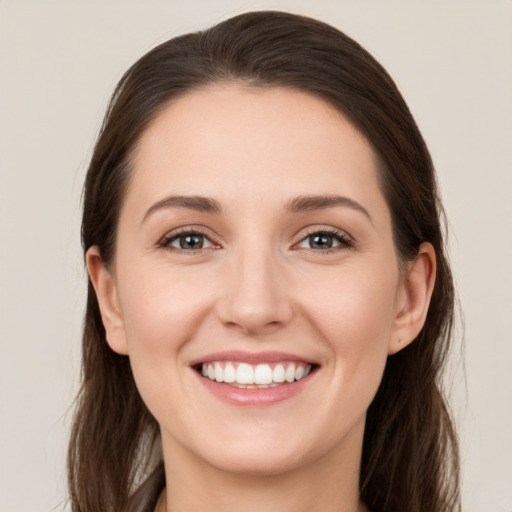 Joyful white young-adult female with long  brown hair and grey eyes