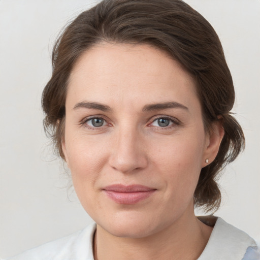 Joyful white young-adult female with medium  brown hair and grey eyes