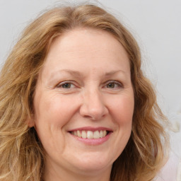 Joyful white adult female with medium  brown hair and blue eyes