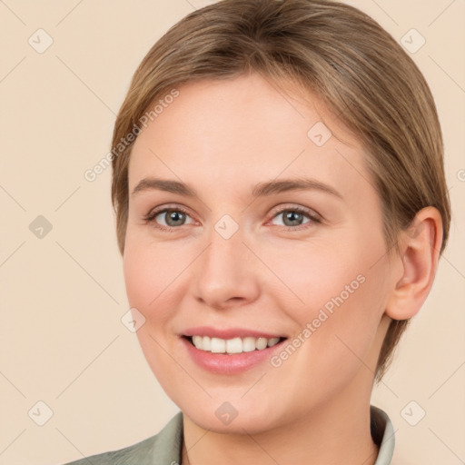 Joyful white young-adult female with medium  brown hair and grey eyes